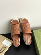 Pair of Gucci brown leather open-toe slide sandals with GG logo on espadrille platform wedge