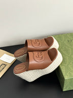Gucci ladies brown leather slide sandals with embossed GG emblem and textured espadrille wedge