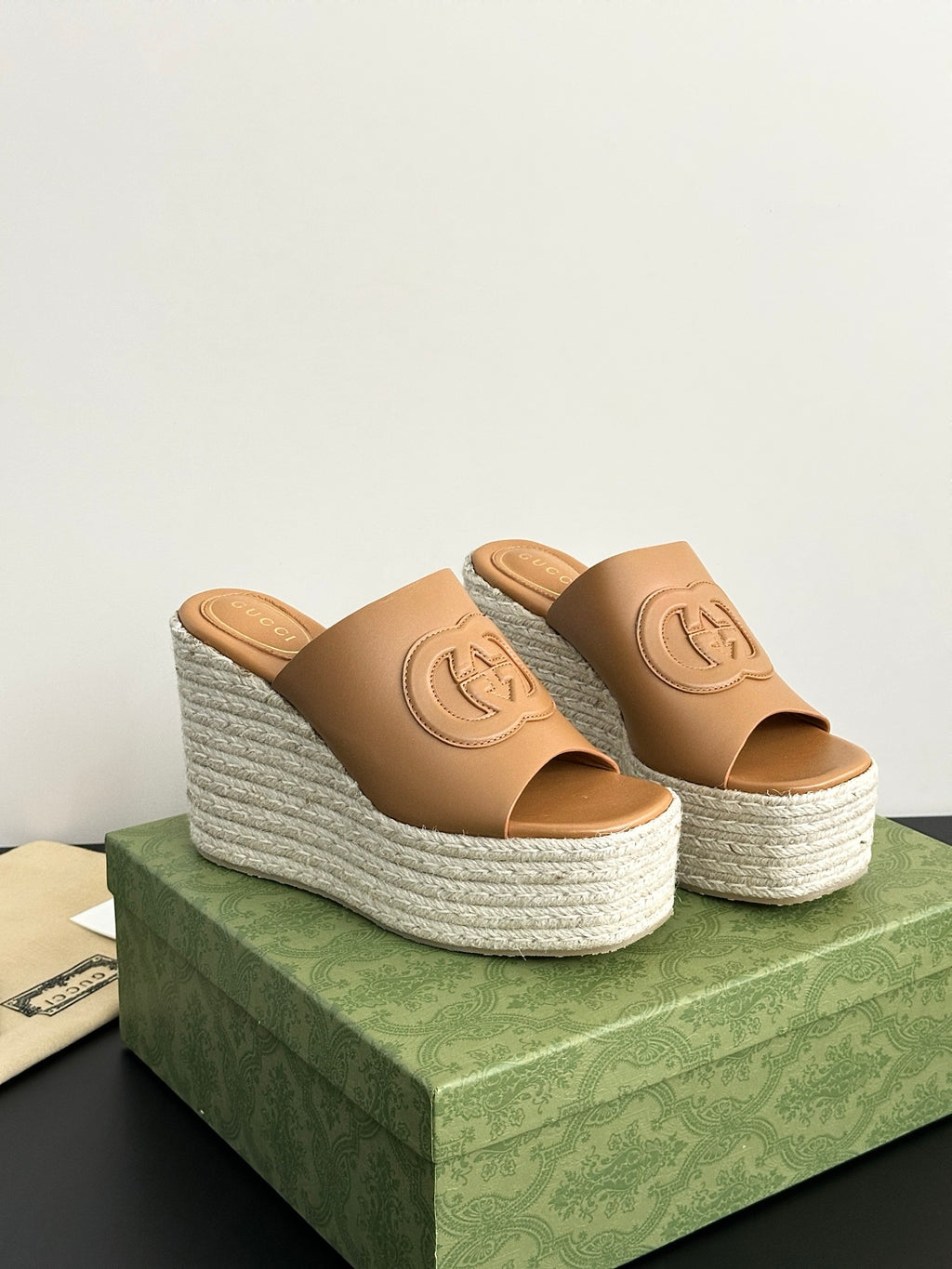 Gucci tan espadrille wedge slide sandals with logo on straps, side angle view.