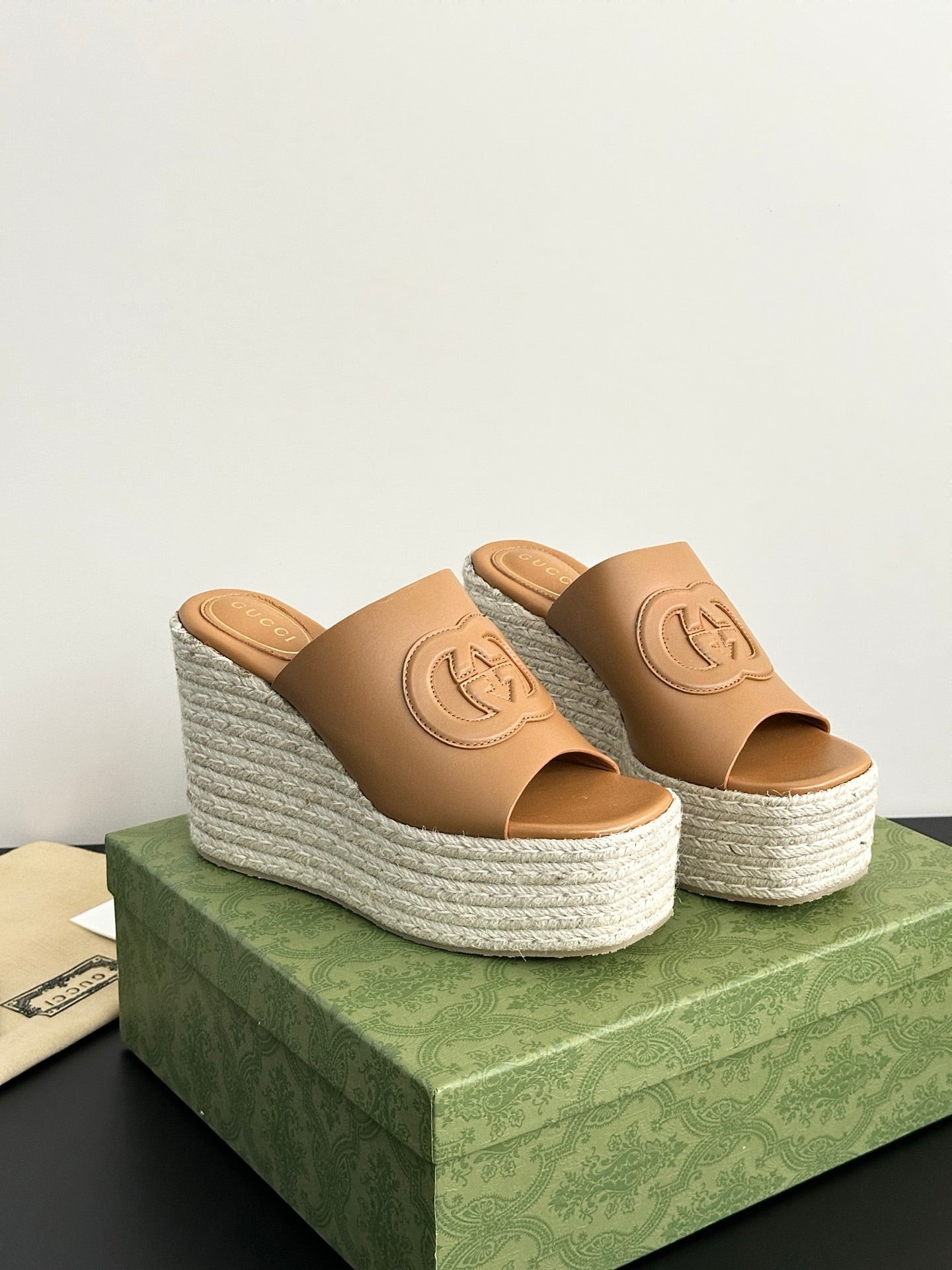 Gucci tan espadrille wedge slide sandals with logo on straps, side angle view.