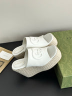 White Gucci platform slides with embossed logo straps and textured rope wedge sole