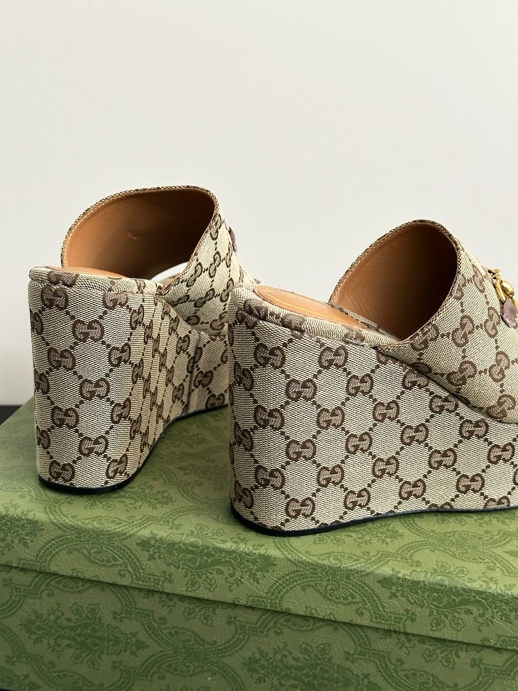 Gucci ladies’ platform slides, rear view; beige-brown GG canvas with gold horsebit hardware