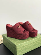 Burgundy Gucci platform mules with GG monogram upper and gold-toned buckle strap