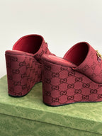 Burgundy Gucci wedge mules, side view, with GG monogram upper and gold buckle