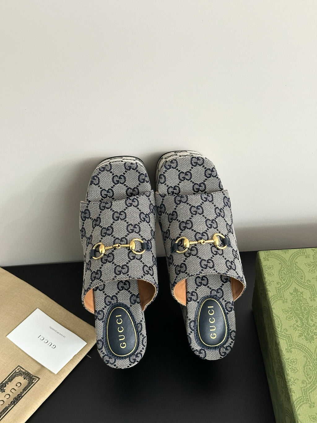 Gucci GG-print platform slide sandals with gold buckle straps, open toe and back view.