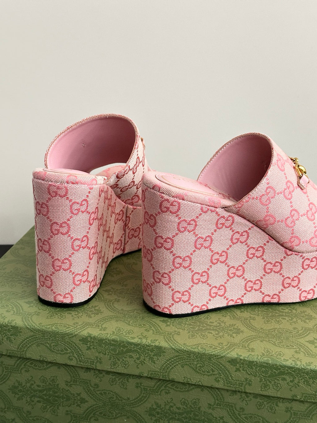 Pink Gucci slide sandals with GG monogram canvas and pink interior at heel.