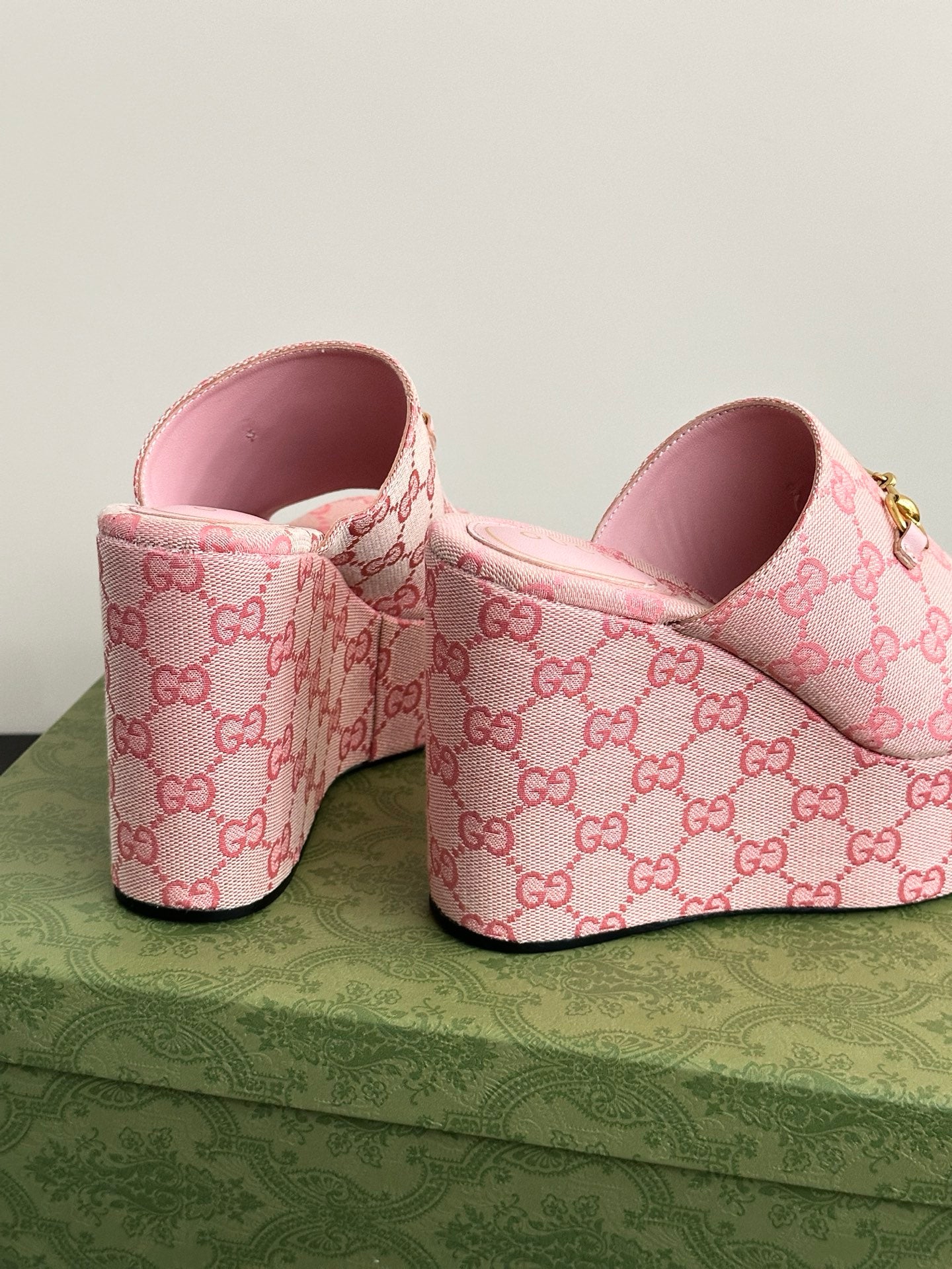 Pink Gucci slide sandals with GG monogram canvas and pink interior at heel.