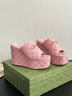 Pink Gucci wedge sandals with GG monogram fabric, gold buckle, thick platform sole.