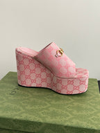 Pink Gucci platform mule with GG monogram upper and gold buckle; open toe.