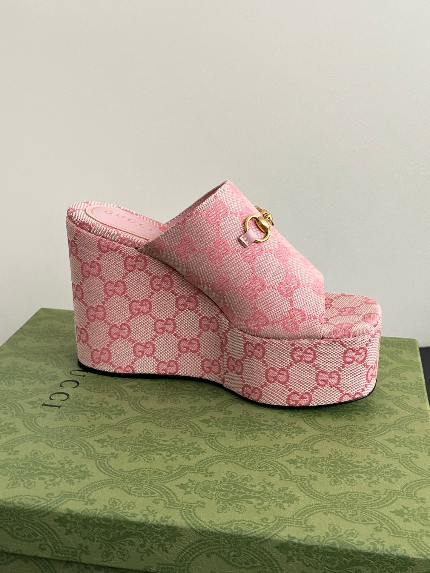 Pink Gucci platform mule with GG monogram upper and gold buckle; open toe.