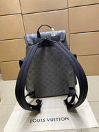 Louis Vuitton monogram backpack with front straps, top handle, and open view, dark gray