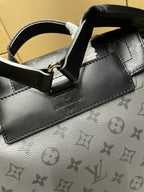 Backpack close-up of grained leather trim, metal ring, and monogram pattern