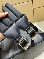 Backpack strap close-up with black adjuster buckle and gray monogram body