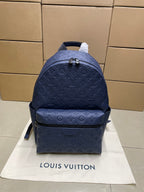 Louis Vuitton monogram backpack in navy blue, front view with top handle and straps