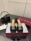 Black mule sandals with gold-tone GG buckle and low block heel