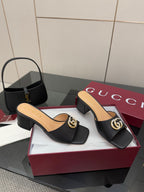 Black mule sandals with gold-tone GG emblem strap and block heel