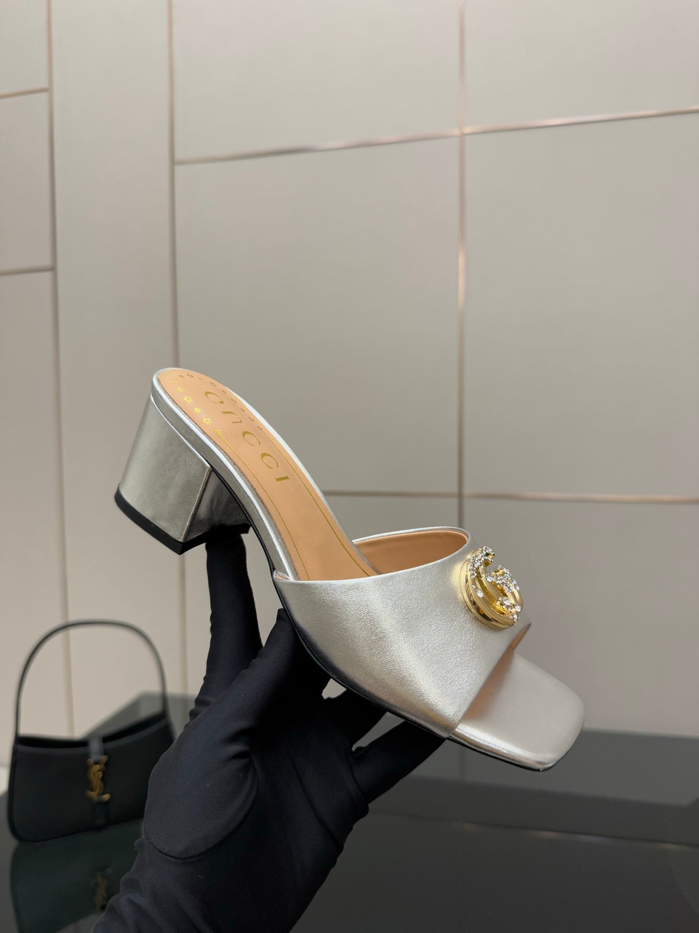 Gucci women's silver mule slide with gold logo ornament and mid block heel