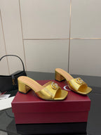 Gucci metallic gold heeled mules with embossed emblem on the front strap