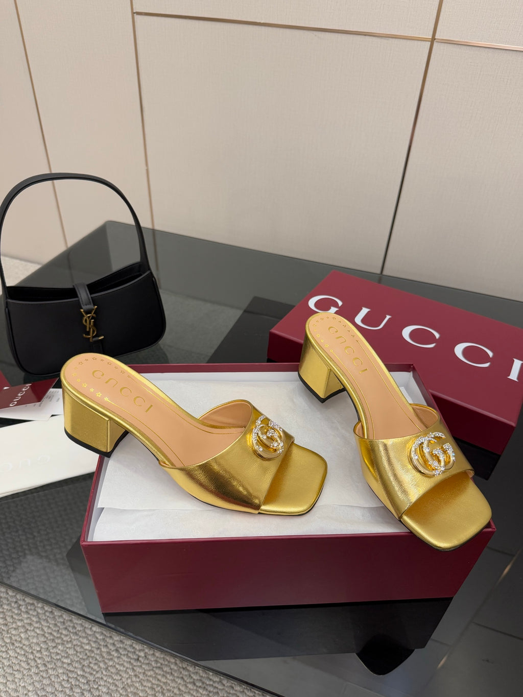 Gucci gold heeled mules with embossed G detail, open toe slide design