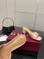 Women’s pink mule sandal featuring gold logo emblem on the strap and cushioned sole
