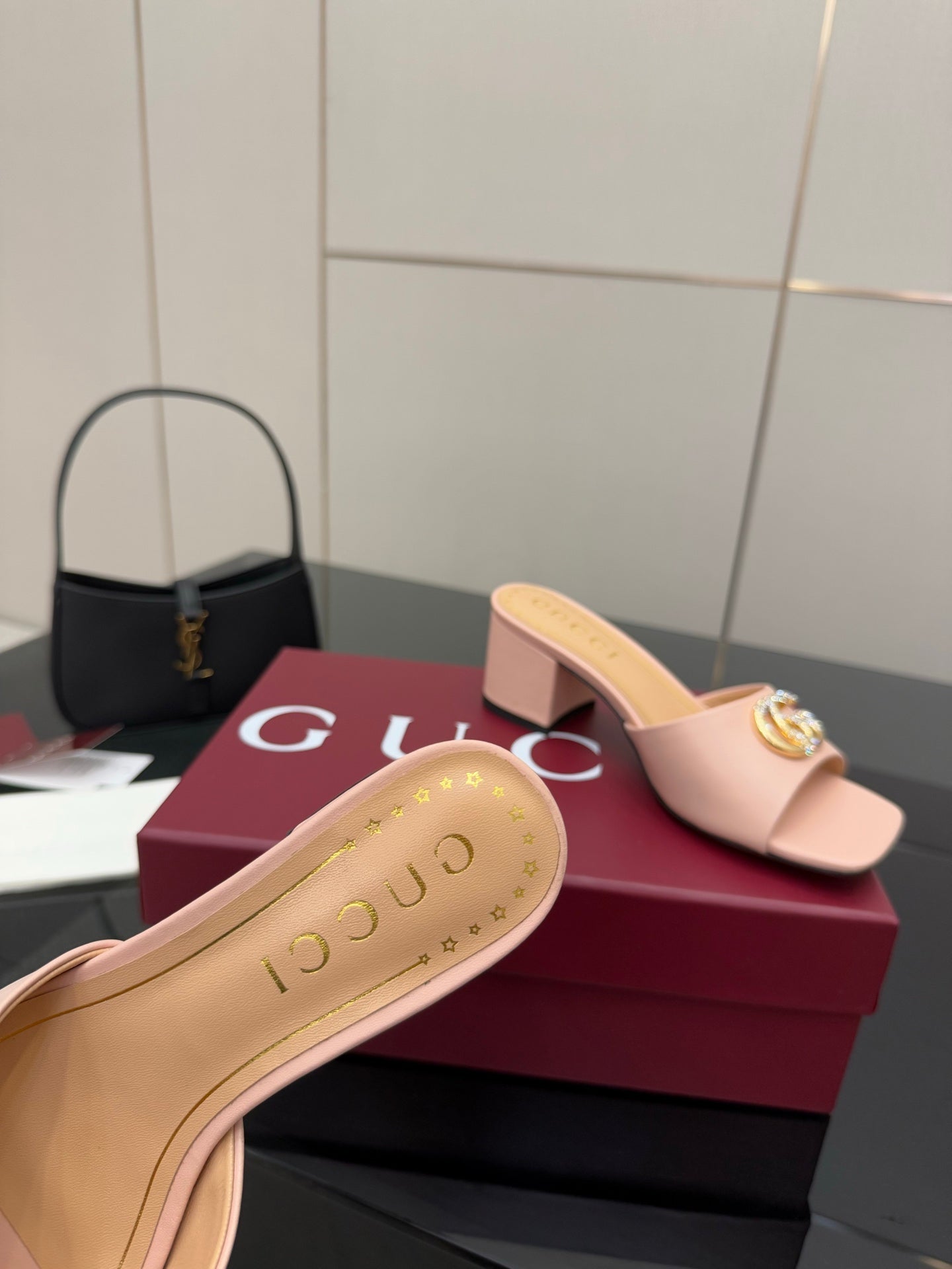 Women’s pink mule sandal featuring gold logo emblem on the strap and cushioned sole