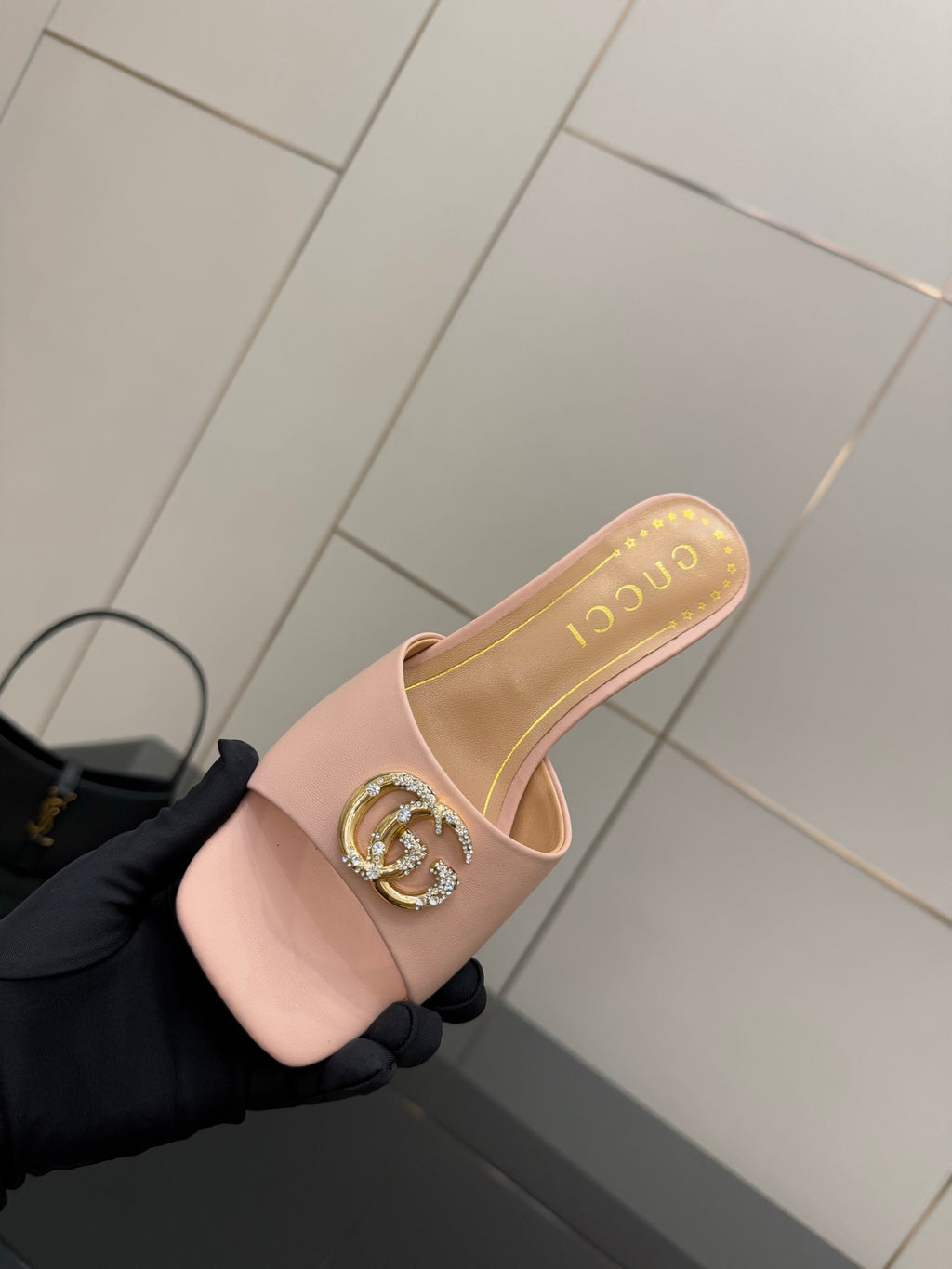 Women’s pink slide mules with gold logo emblem and cushioned insole detail