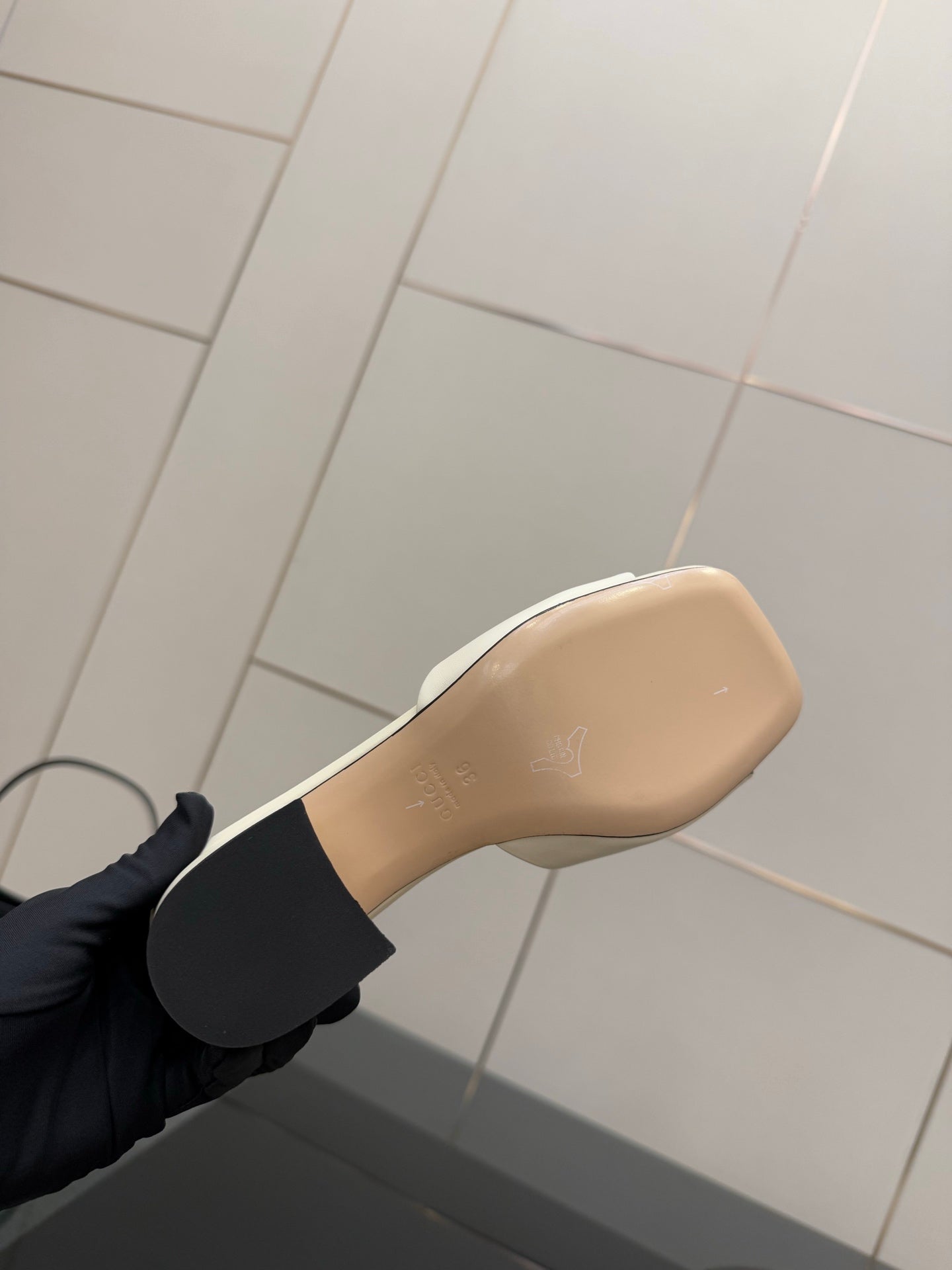 Gucci ladies cream mule outsole view with gold-tone lettering, heel area close-up