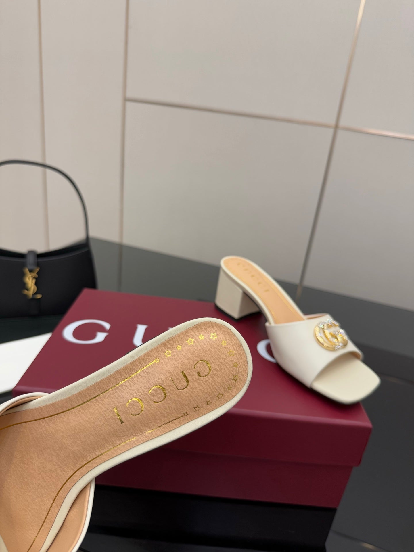 Gucci ladies cream mule sole detail with gold-tone lettering, single shoe close-up