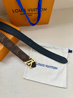 Navy leather belt with gold-tone buckle, monogram backing, on dust bag