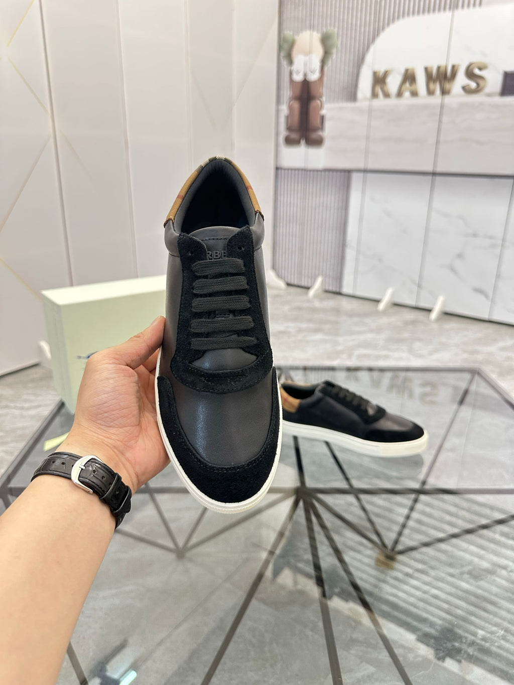 Burberry sneakers with black upper and white sidewall sole; tan detail on heel lining
