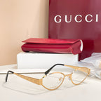 Gold round eyeglasses with clear lenses, GG-pattern temples, and black arms.