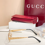 Gold eyeglasses with GG-pattern arms, black tips, and clear lenses.