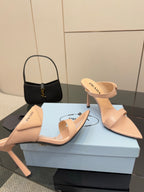 Prada women’s light beige mules with stiletto heels, angled front view pair
