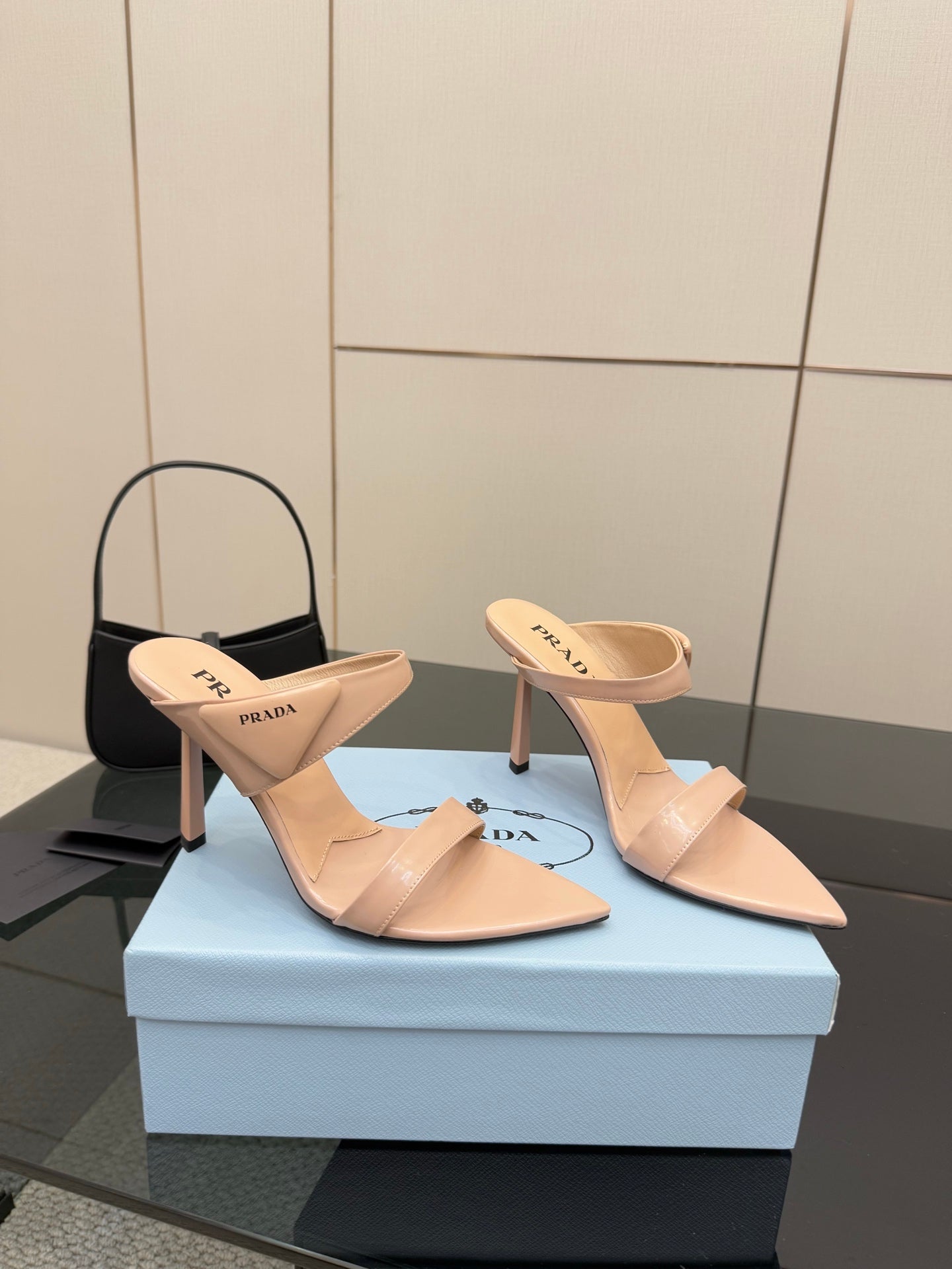 Prada women’s light beige mules with stiletto heels, angled side view pair
