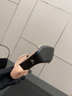 Prada women’s light beige mule outsole view, black bottom with logo