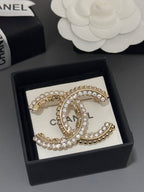 Gold-tone rhinestone Chanel brooch in black box with oval C centerpiece