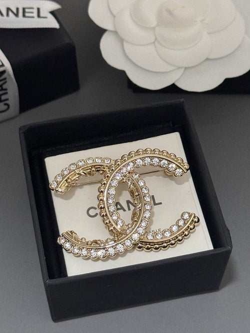 Gold-tone rhinestone Chanel brooch in black box with oval C centerpiece