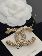 Gold-tone rhinestone Chanel brooch with pin back and oval C design on card