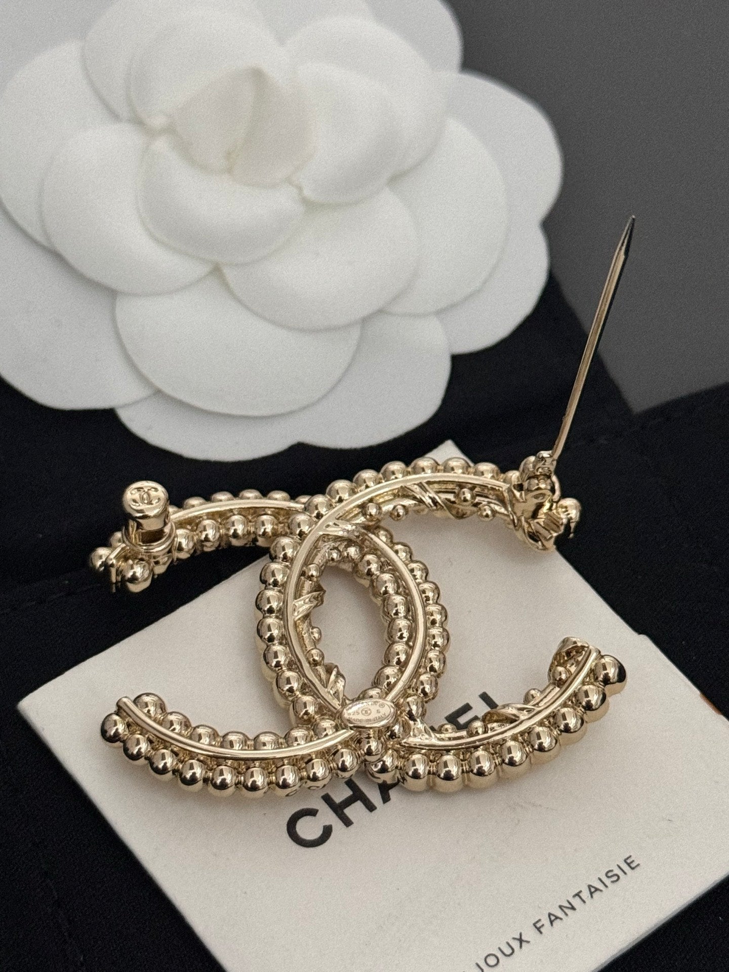 Gold-tone rhinestone Chanel brooch with pin back and oval C design on card