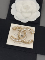 Gold-tone rhinestone Chanel brooch, oval C charm with bead-like trim