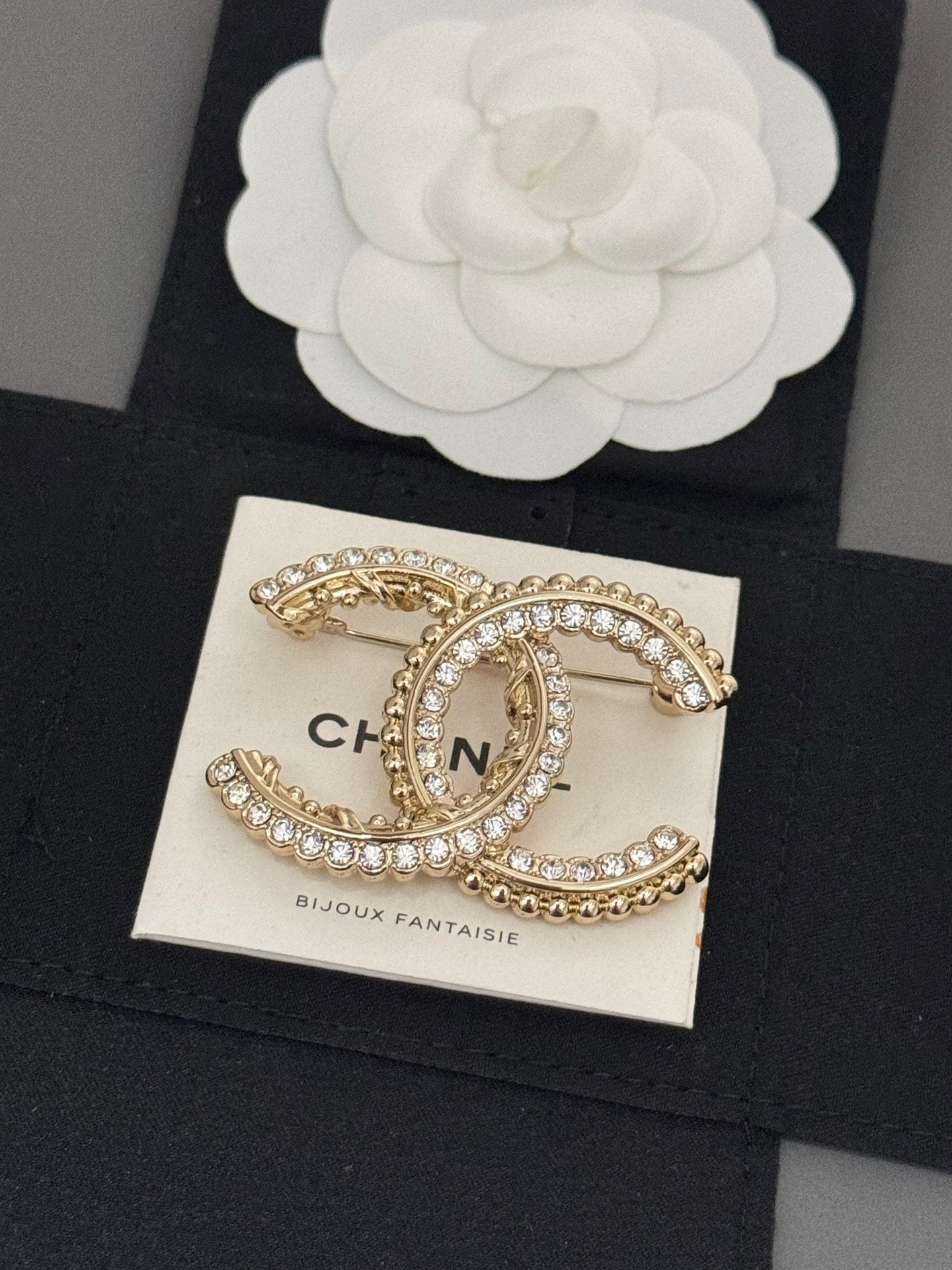 Gold-tone rhinestone Chanel brooch, oval C charm with bead-like trim