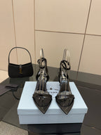 Black patent high-heel sandals with ankle strap and pointed toe, branding detail