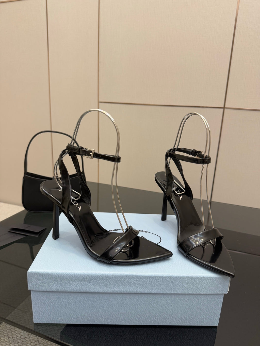 Pair of black high-heel sandals with thin ankle straps and glossy finish