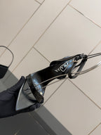 Black patent sandal sole view with ankle strap and stiletto heel