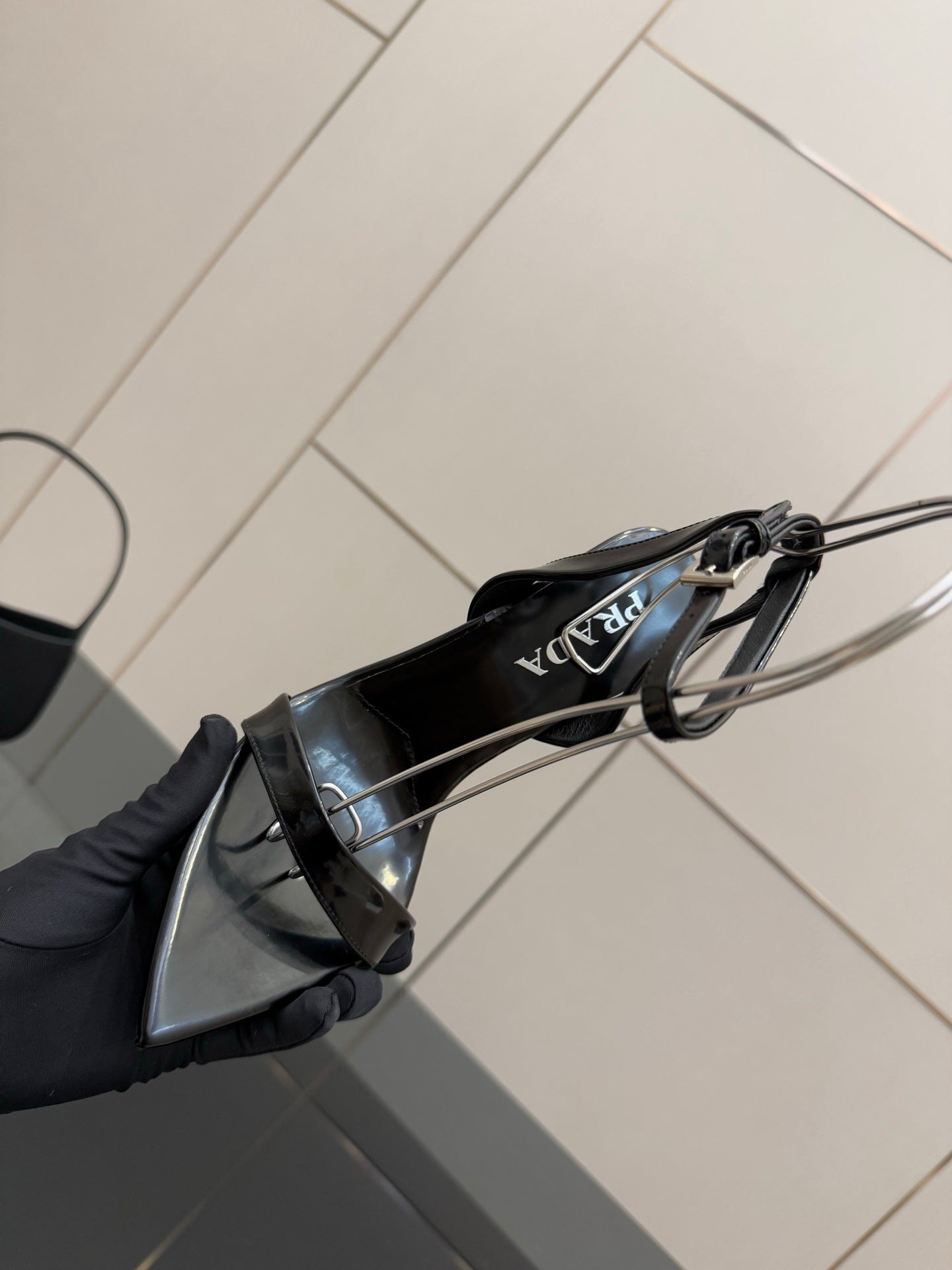 Black patent sandal sole view with ankle strap and stiletto heel