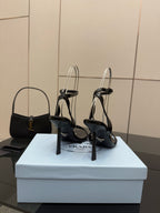 Black high-heel sandals on display with ankle straps and glossy finish