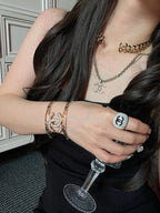 Gold-tone Chanel charm bracelet set and chain necklace on wrist and neck
