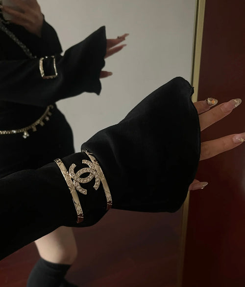 Black fabric cuff bracelet with gold-tone Chanel logo and chain details