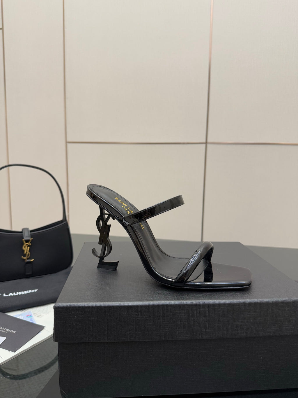 Black patent heeled mule with open toe and thin ankle strap, side view