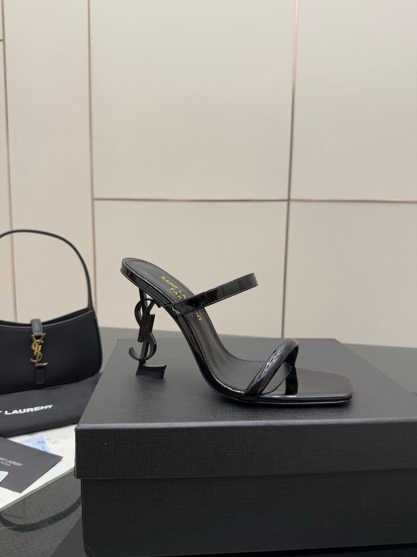 Black patent heeled mule with open toe and thin ankle strap, side view